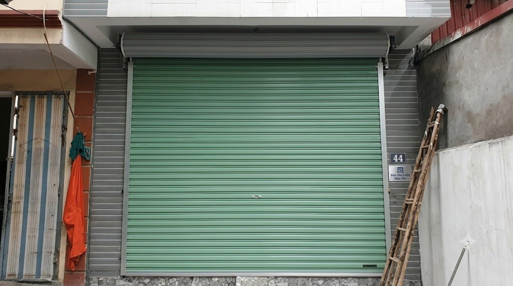 Kỹ thuật viên đang kiểm tra và gỡ rối nan cửa cuốn bị xô lệch tại khu công nghiệp Bàu Bàng