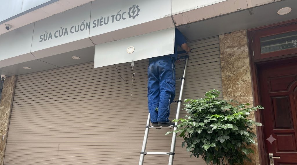 Kỹ thuật viên khắc phục lỗi kẹt nan cửa cuốn tại đường Cách Mạng Tháng Tám, Cẩm Lệ